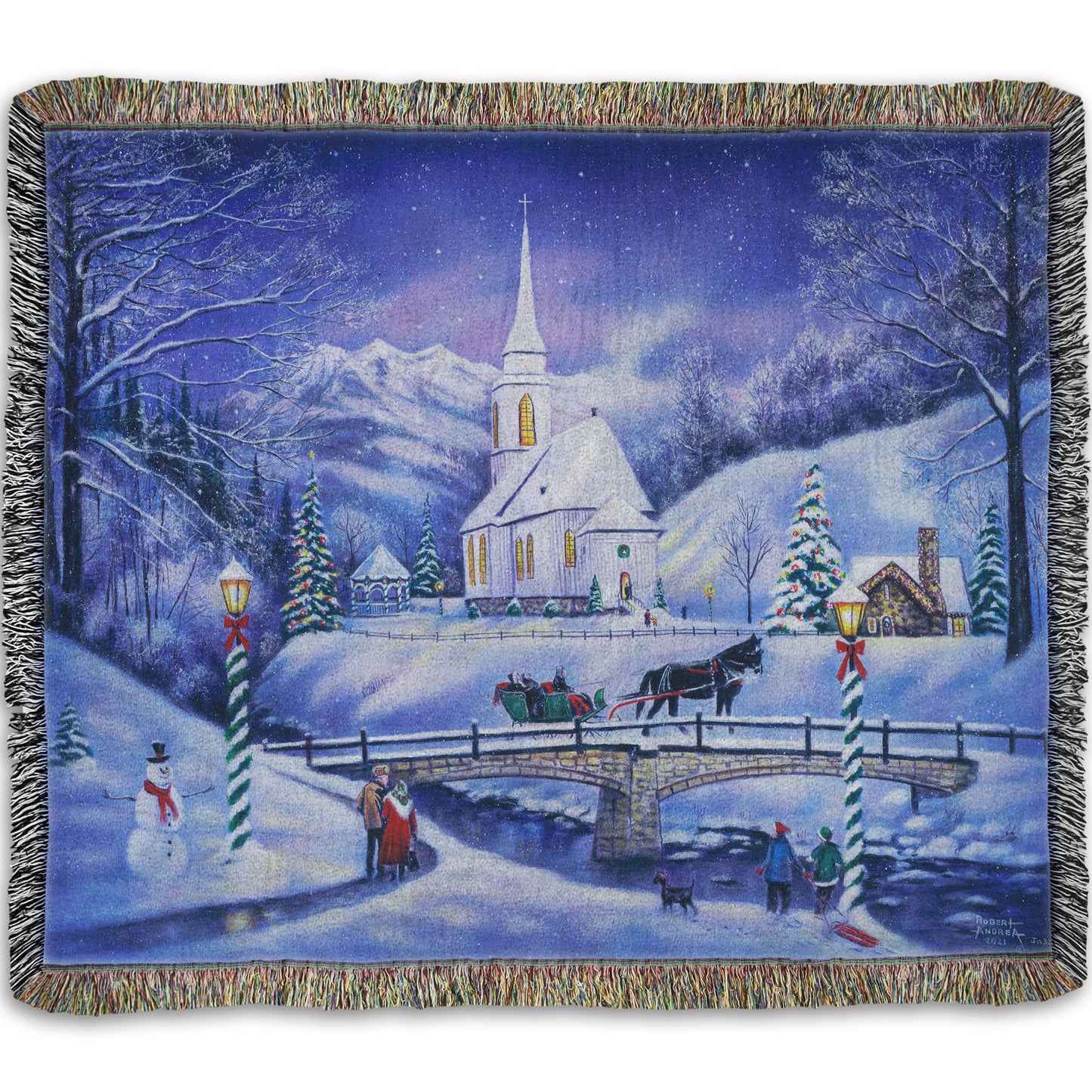 A woven throw blanket designed with a snowy mountain town, decorated for Christmas. A tall church sits in the middle of town.