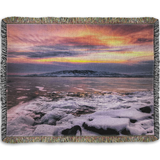 A woven throw blanket designed with the photo of a sunset over an icy lake at Mount Timpanogos, Utah, one Christmas evening.