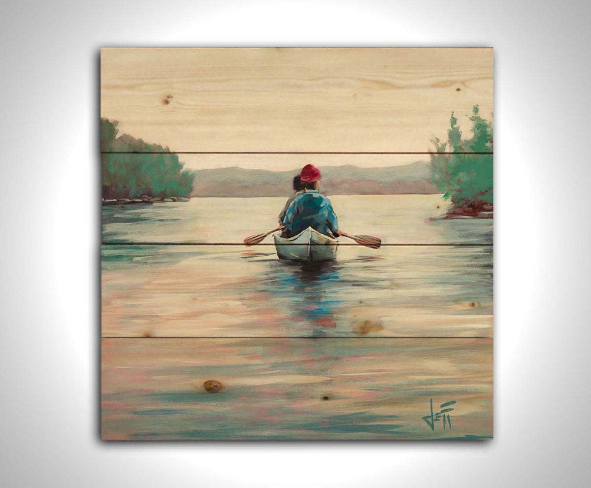A painting of two people paddling a canoe across a lake in the early morning. The sky is pale reflecting on the water, and green trees line the shore along the lake. Printed on a wood pallet.