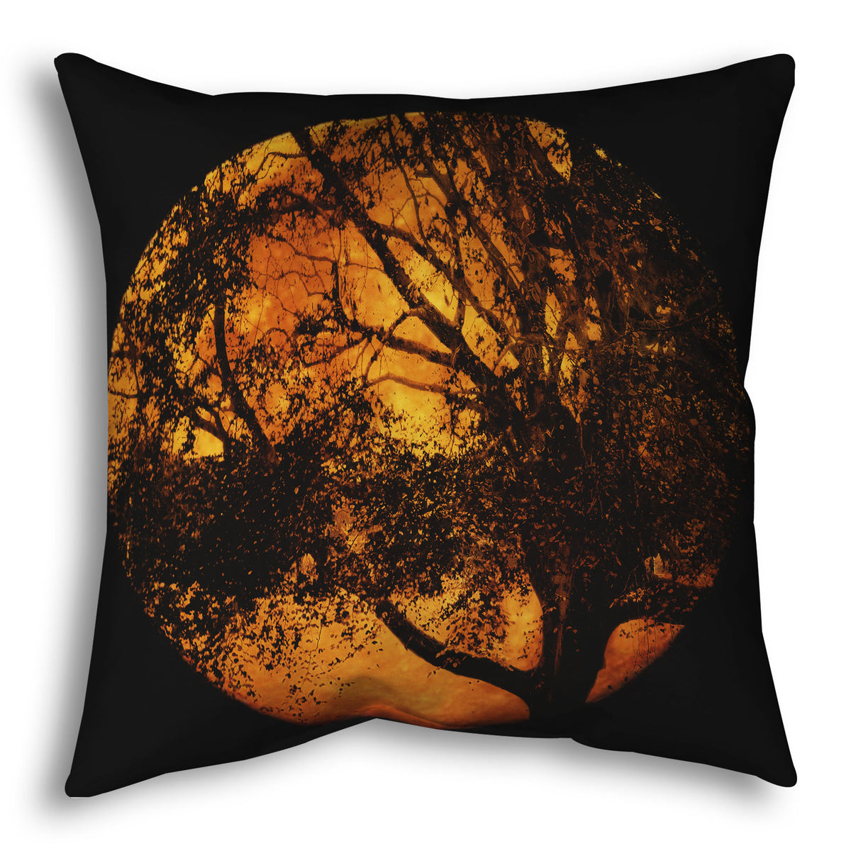 A throw pillow designed with a photo of the black shadow of a tree superimposed over a bright orange full moon.
