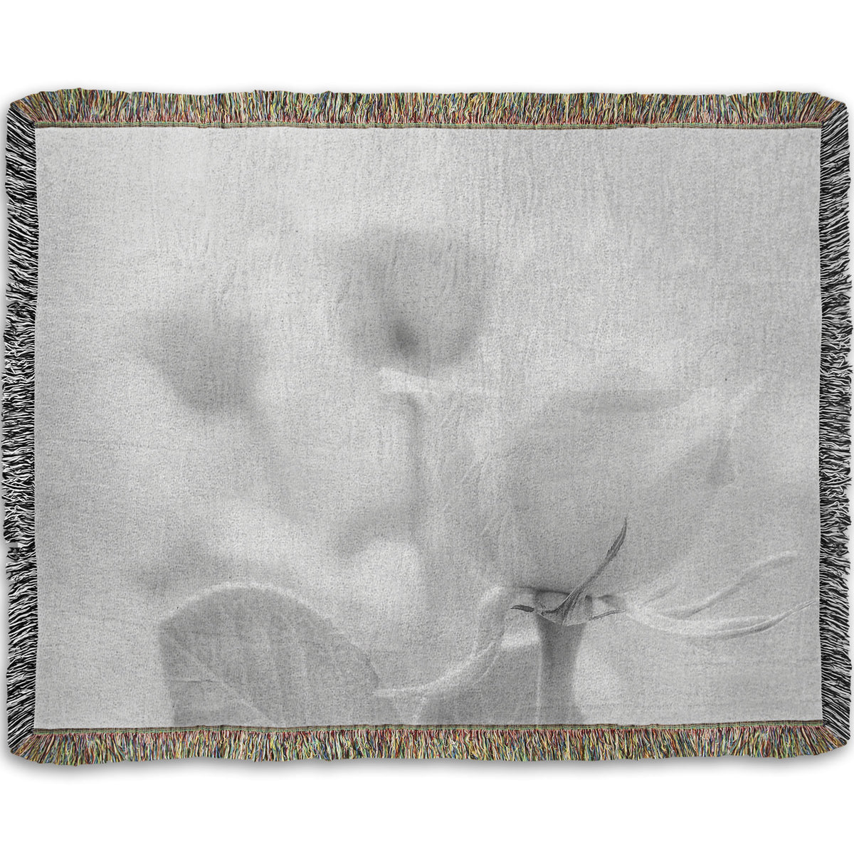 A woven throw blanket designed with a grayscale photo of three roses bathed in a soft white light.