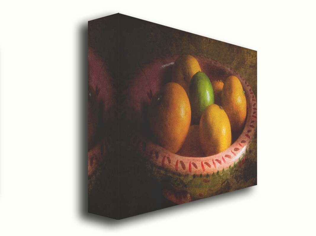 A photo of a bowl of oranges, with one lime placed in the center. Printed on canvas.