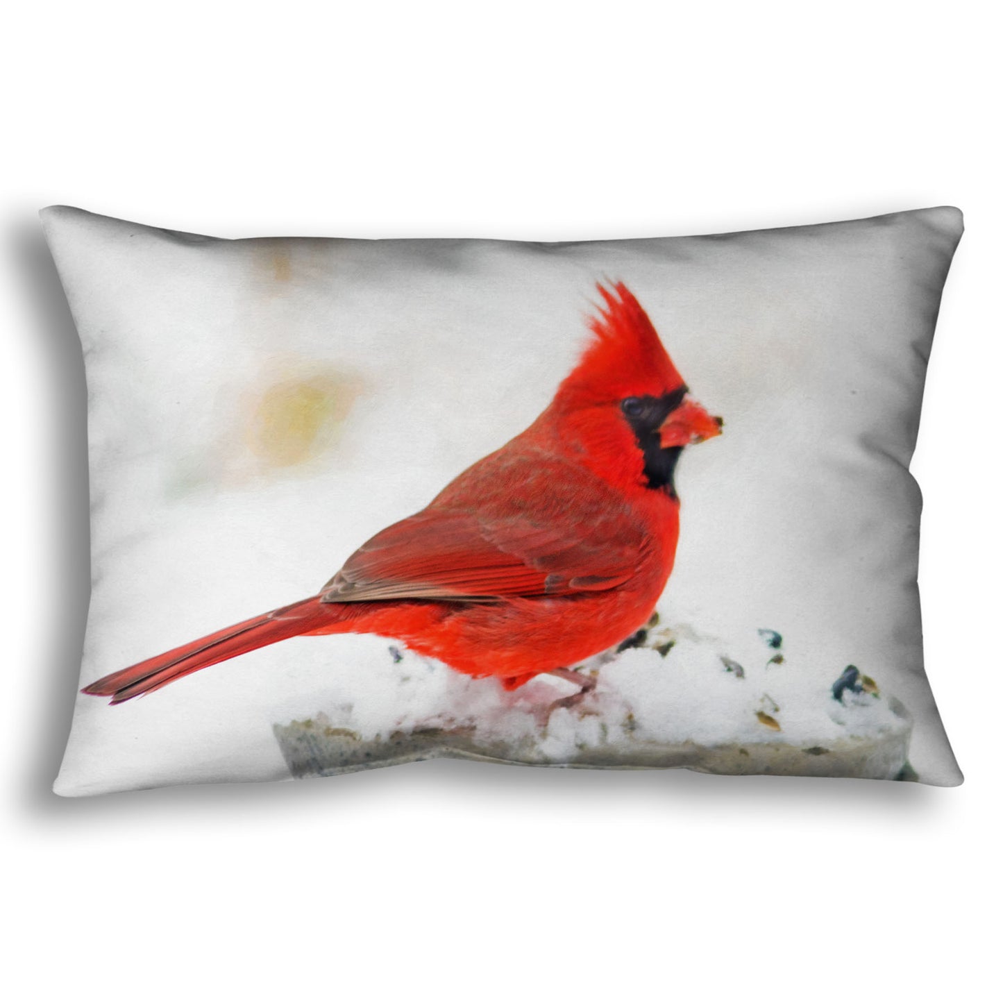 A throw pillow printed with a photograph of a red cardinal against white snow.