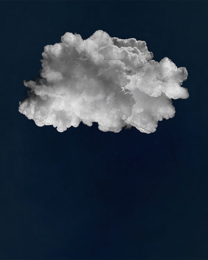 A photo edit of a large, fluffy white cloud against a deep blue background.