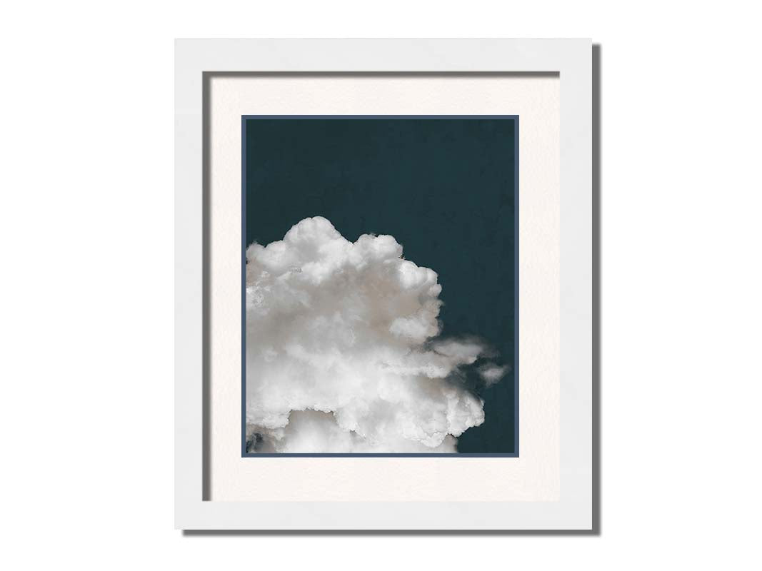 An edited photo of a fluffy white cloud against a deep navy blue background. Printed on paper, matted, and framed.