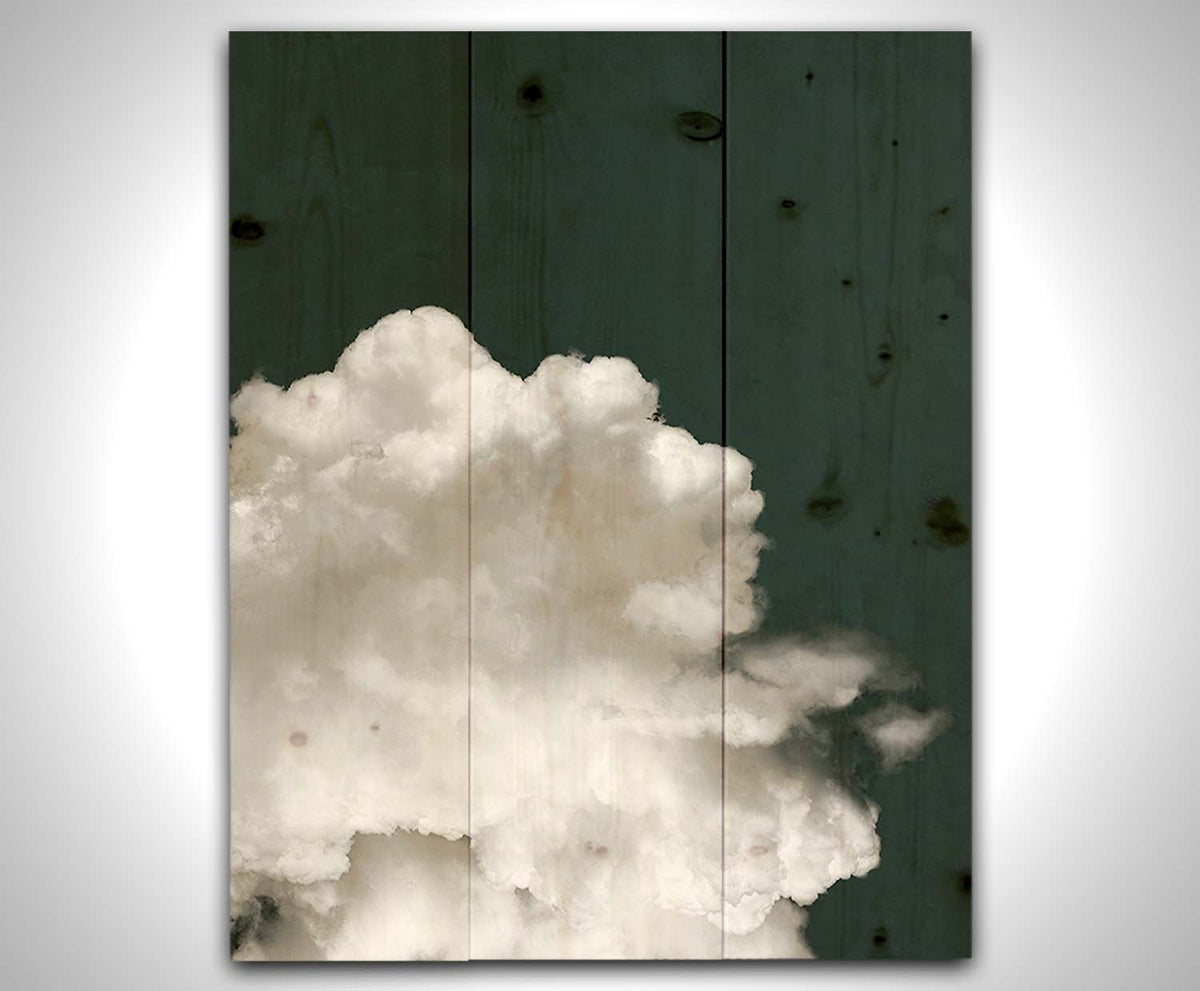 An edited photo of a fluffy white cloud against a deep navy blue background. Printed on a wood pallet.