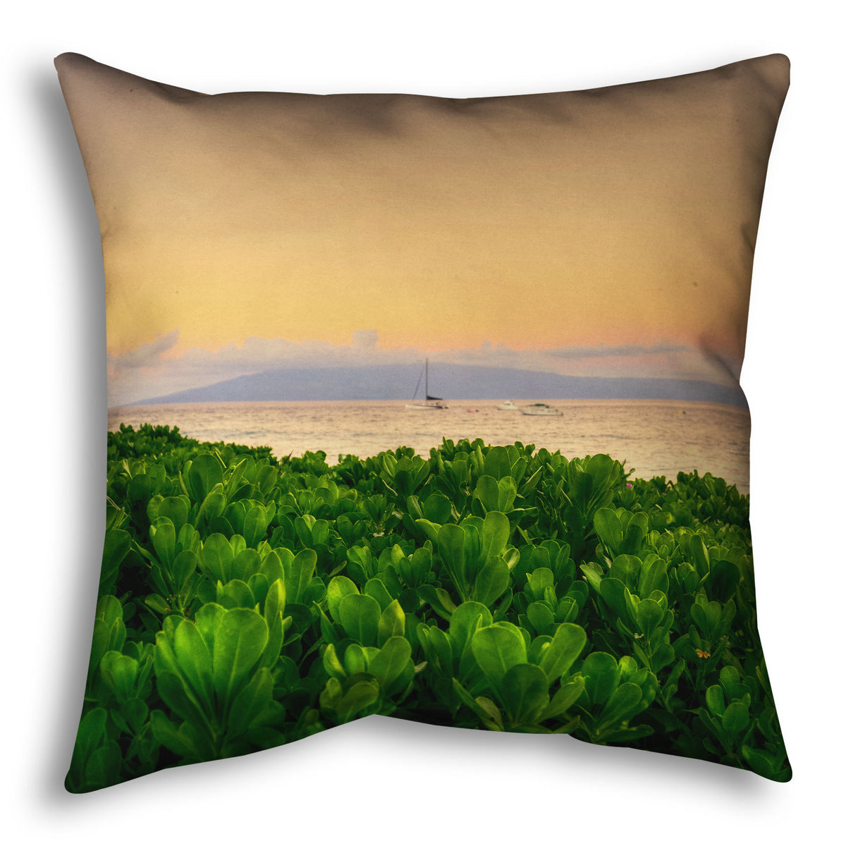 A throw pillow designed with a photo overlooking the sea from Kaanapali beach in Hawaii. Green plants fill the foreground, and boats sail on the water in the distance against a gentle orange sky and purple clouds.