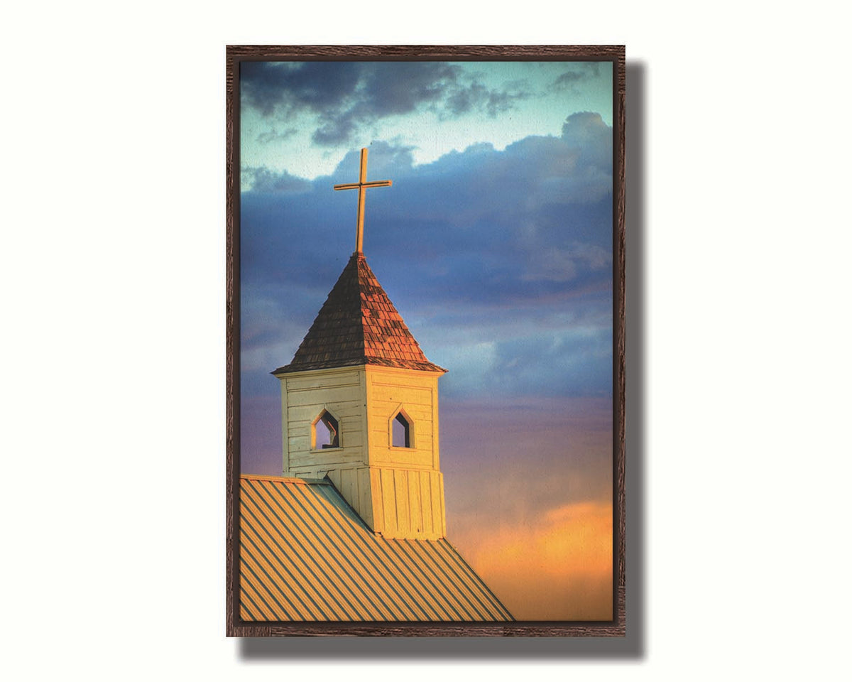 A photo of a cross-topped church at sunset, the sky gradating from blue to purple to orange. Printed on canvas in a float frame.