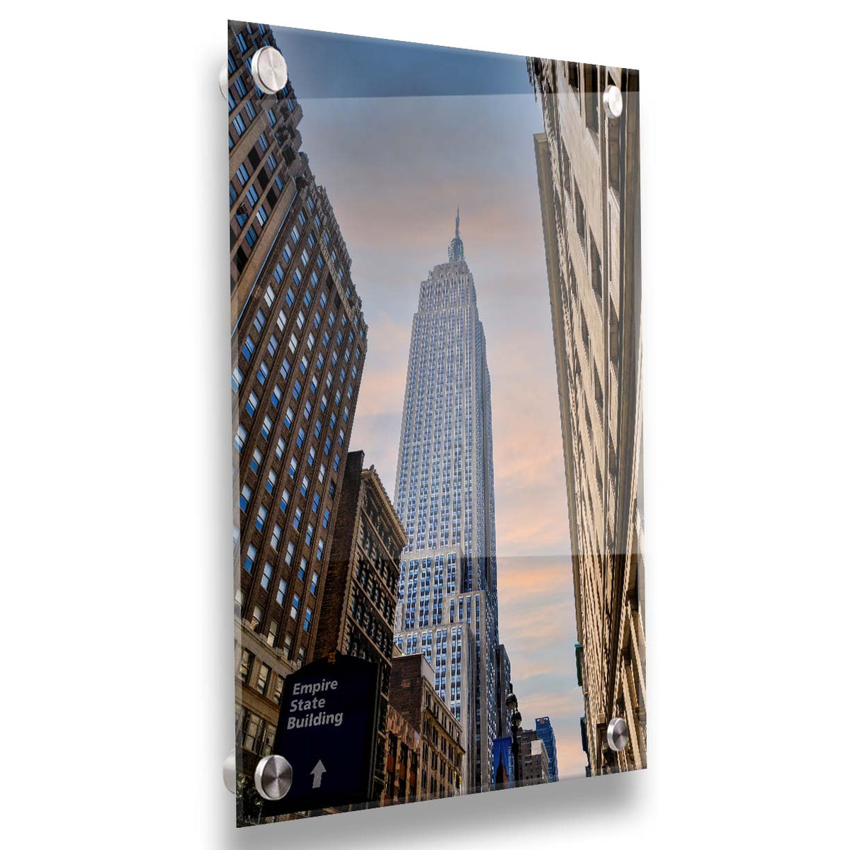 A photograph looking up at the Empire State Building in New York against a blue sky and orange clouds. Printed on acrylic.