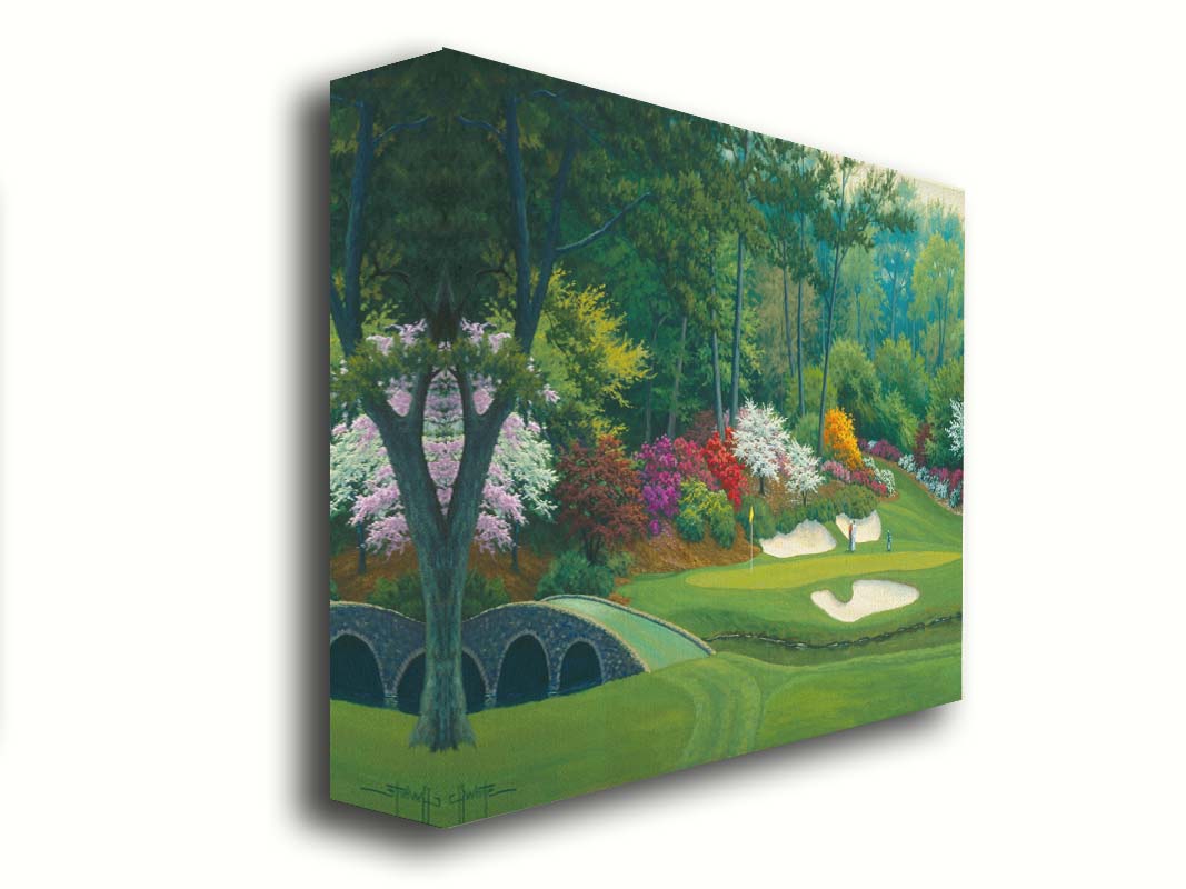 A painting of the Augusta Nationals golf course in Georgia. The course is encircled by foliage and flowers of all colors, and a bridged stream runs through the center. A few golfers stand near a small sand pit, lining up a shot to the nearby hole. Printed on canvas.