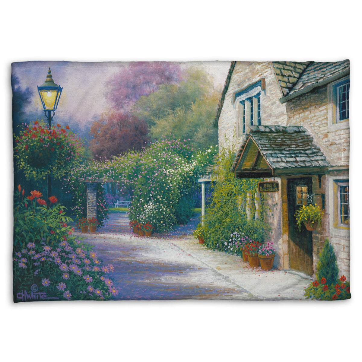 A fleece throw blanket designed with a painting of a bed and breakfast storefront, with a streetlamp-lined path leading to the garden full of blooming flowers.