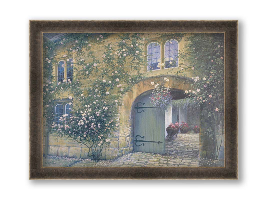 A painting of an arched doorway passing through a building into a courtyard. The building and courtyard are decorated with bushes and vines sprouting an assortment of white and red flowers. Printed on canvas and framed.