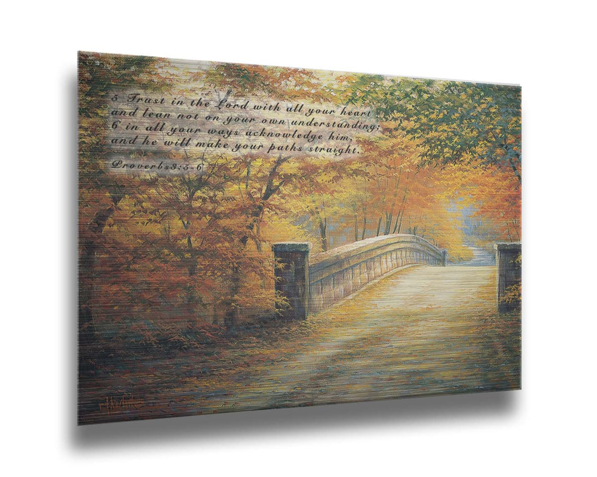 A painting looking down a bridge road during fall. The trees lining the road have turned yellow and orange for autumn, and some of their fallen leaves are scatted along the path. It is overlaid in the upper left with Proverbs 3:5-6 of the Bible, reading "5. Trust in the Lord with all your heart and lean not on your own understanding; 6. In all your ways acknowledge him, and he will make your paths straight." Printed on metal.