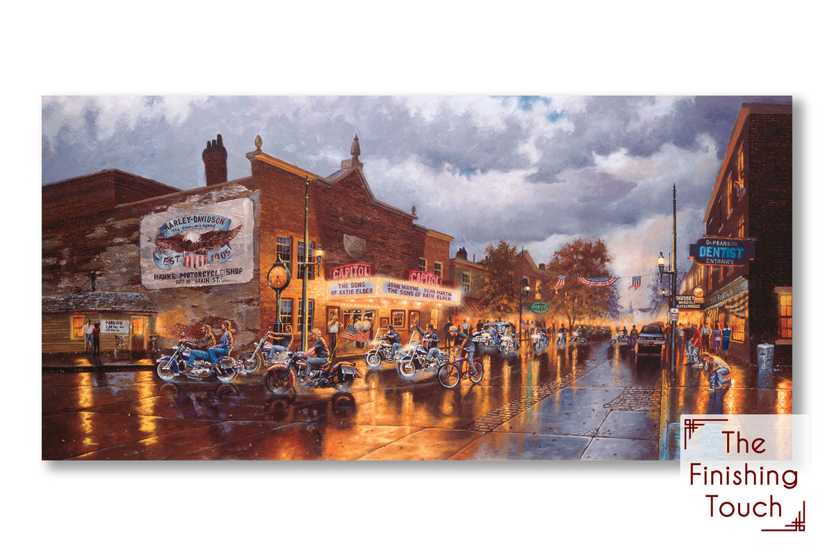 A painting of a group of bikers riding their motorcycles down a town road past a Harley Davidson motorcycle shop, a movie theater, and other shops. The sky is cloudy, and the shop lights reflect off the damp pavement.