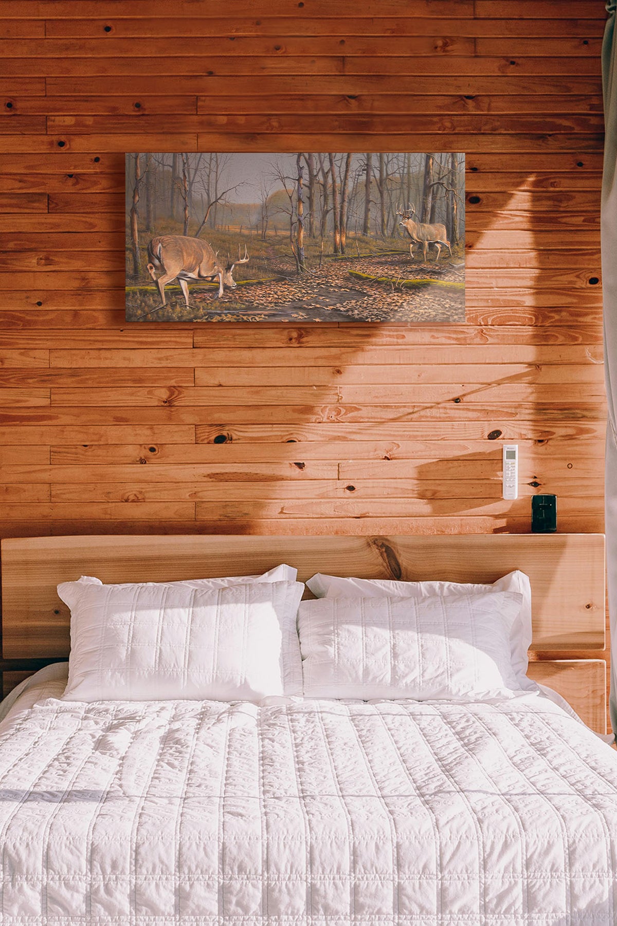 A painting hanging on a bedroom wall. A painting of two deer approaching each other in the woods. The two bucks are about to fight, as is evident by their body language. Printed on canvas.