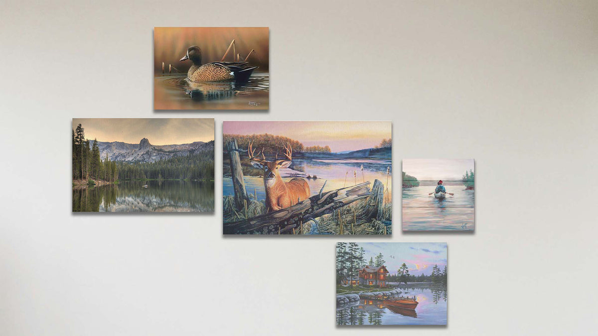 A collage of art in the standard By Dawn's Early Light package, including a canvas painting of a deer standing in a lake at sunrise, a canvas painting of a blue-winged teal swimming in a brown scene, a canvas painting of a lakeside cabin and docked rowboat, a canvas painting of a calm lake reflecting the low sun, and a box board painting of people paddling a canoe across a lake on a peaceful, misty morning.