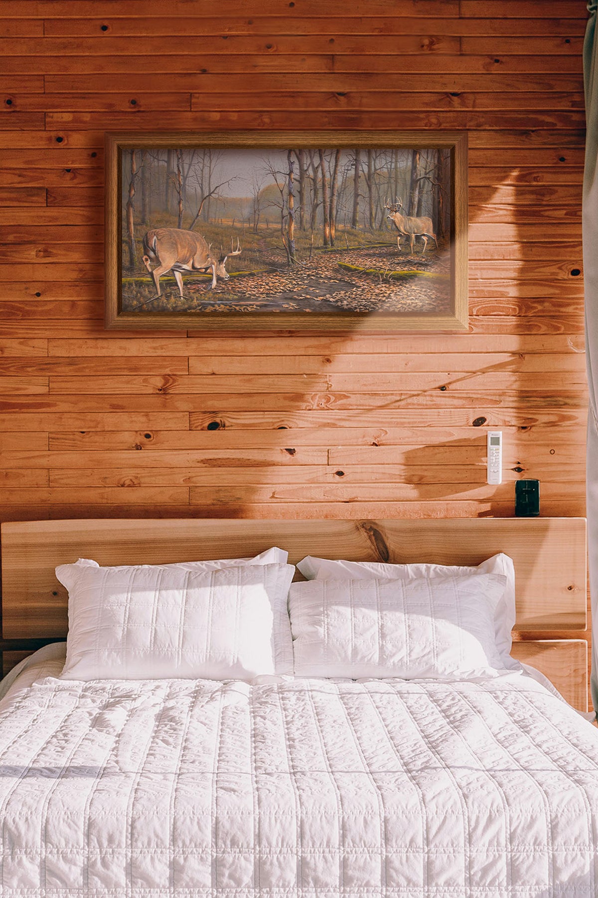 A painting hanging on a bedroom wall. A painting of two deer approaching each other in the woods. The two bucks are about to fight, as is evident by their body language. Printed on canvas and framed.
