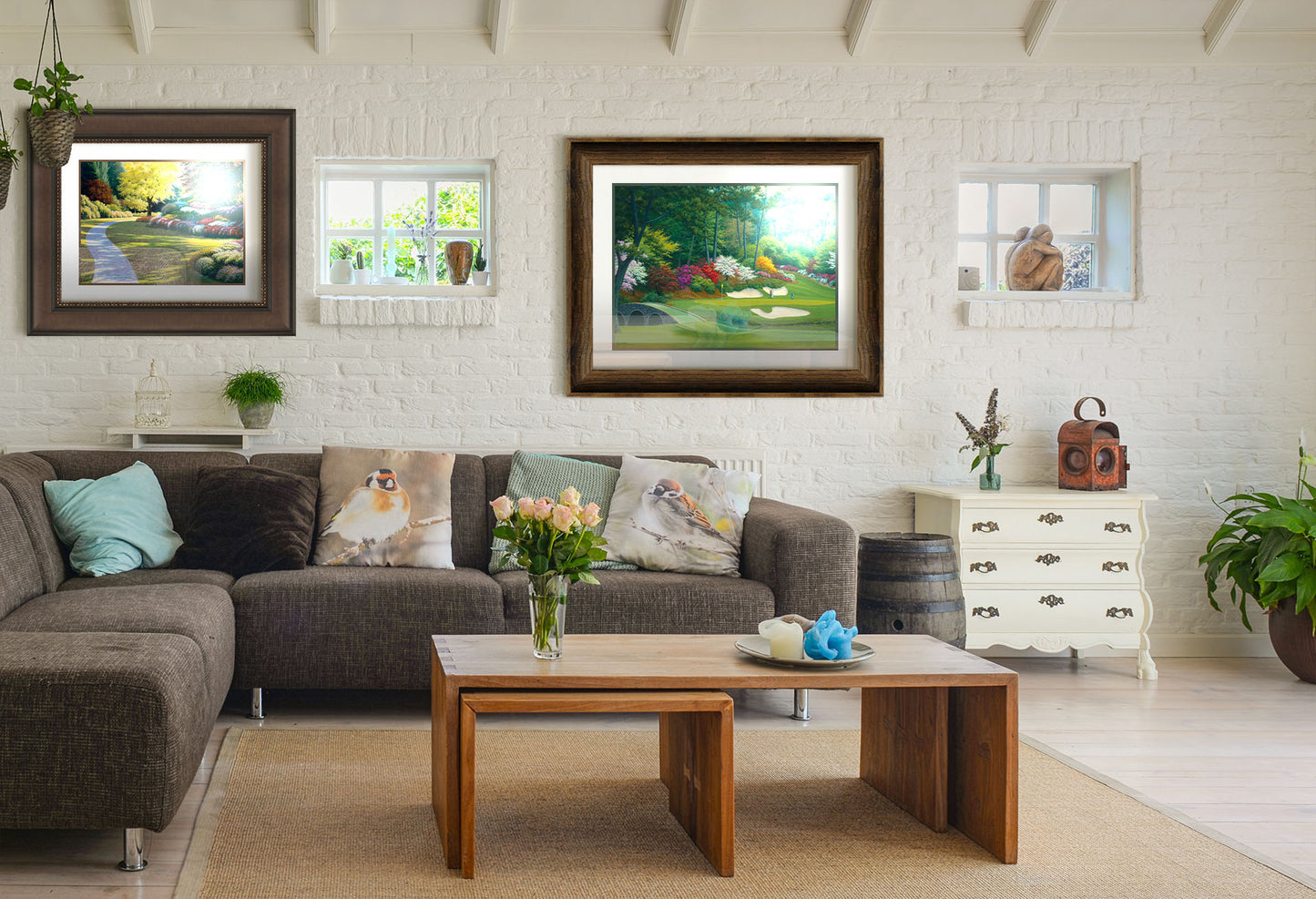 A painting hanging on a living room wall. The first is a painting of a cobblestone path through a sunny, colorful, tidy garden. Printed on paper, matted, and framed. The second is a painting of the Augusta Nationals golf course in Georgia. The course is encircled by foliage and flowers of all colors, and a bridged stream runs through the center. A few golfers stand near a small sand pit, lining up a shot to the nearby hole. Printed on paper, matted, and framed.