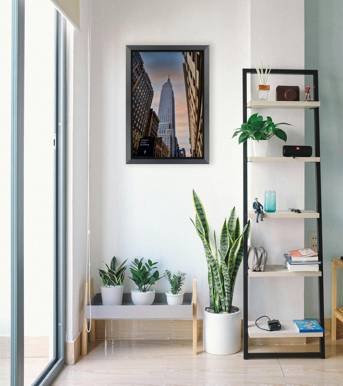 A photograph looking up at the Empire State Building in New York against a blue sky and orange clouds. Printed on canvas and framed.