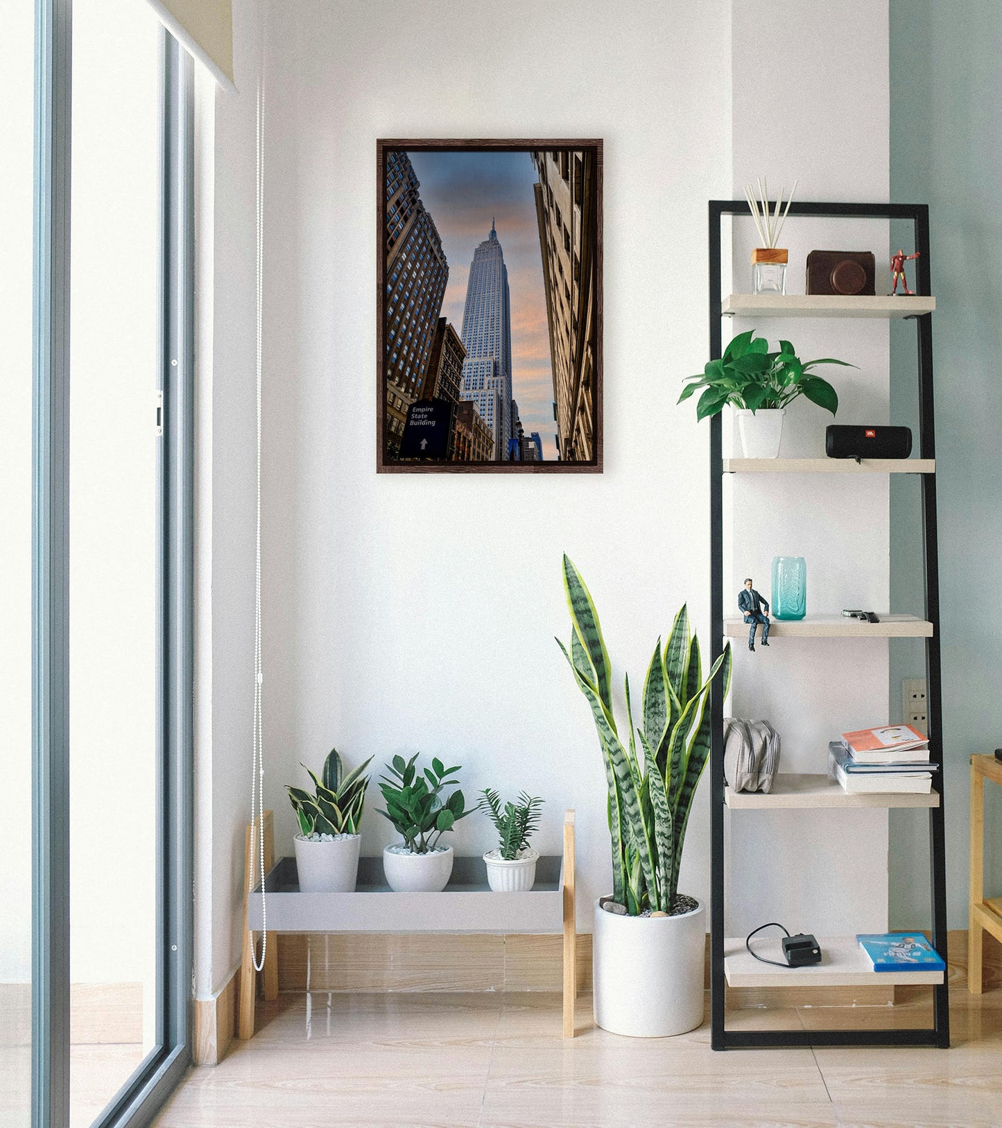 A photograph looking up at the Empire State Building in New York against a blue sky and orange clouds. Printed on canvas in a float frame.
