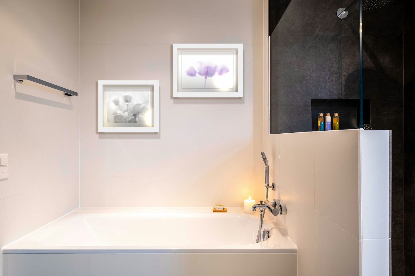 Two photographs hanging on a bathroom wall. The first is a grayscale photo of three roses bathed in a soft white light. Printed on paper, matted, and framed. The second is a photo of three pale purple roses against a pure white background, enveloped in a gentle white glow. Printed on paper, matted, and framed.