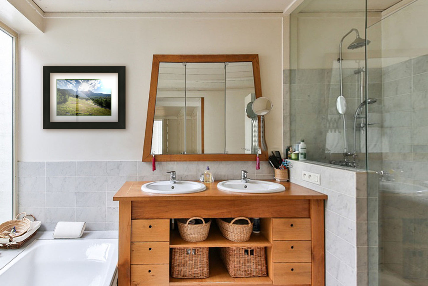 A photograph hanging on a bathroom wall. A photo of the sun shining brightly over Mount Timpanogos. The hillsides and forest are the fresh green of springtime. Printed on paper, matted, and framed.