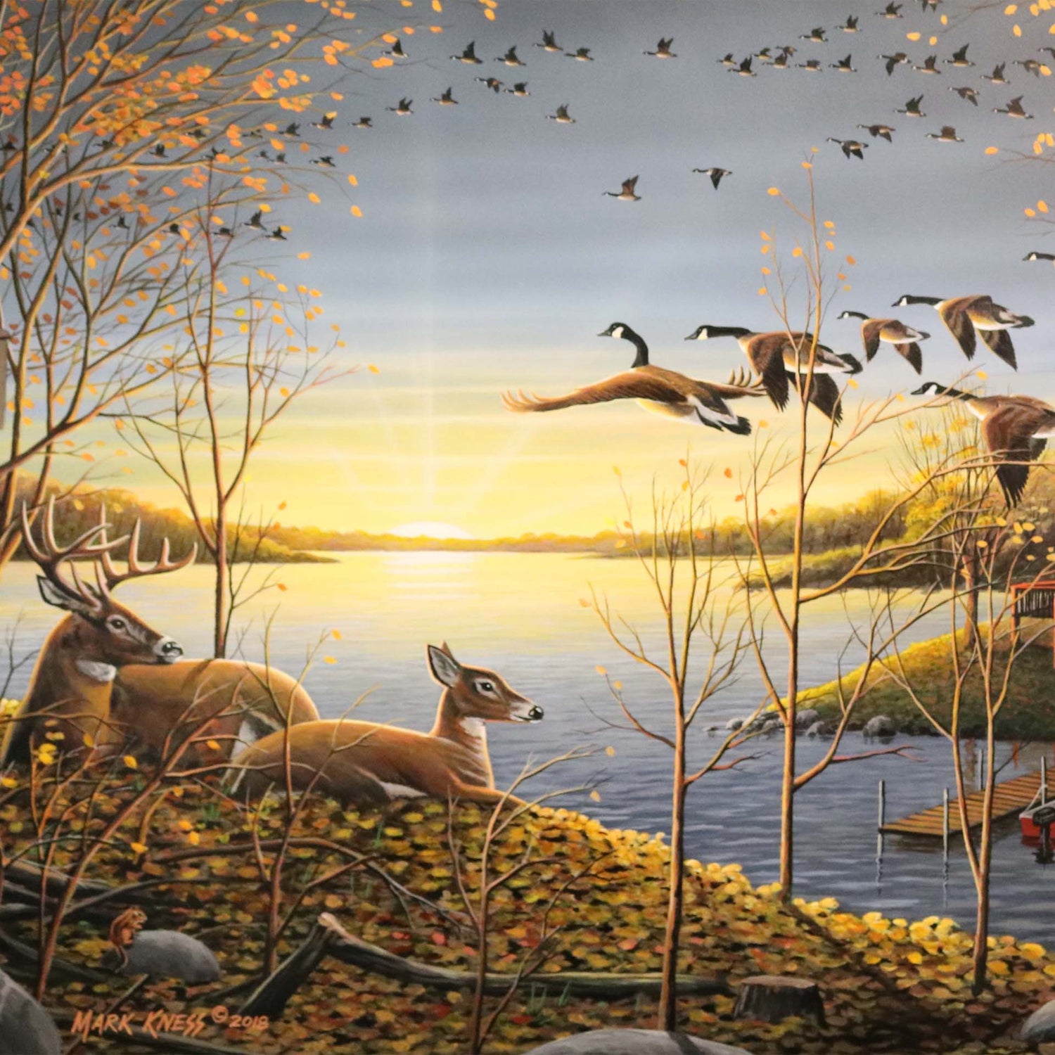 A painting of a lake scene by Mark Kness. Deer overlook a lakehouse as geese fly overhead at sunrise. 