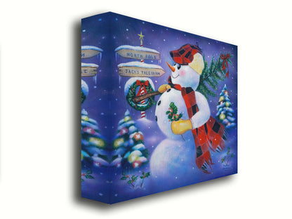 A painting of a snowman carrying a small Christmas tree, holding holly. It is standing by a sign indicating that it is taking the tree from Jack's Tree Farm to the North Pole. Printed on canvas.