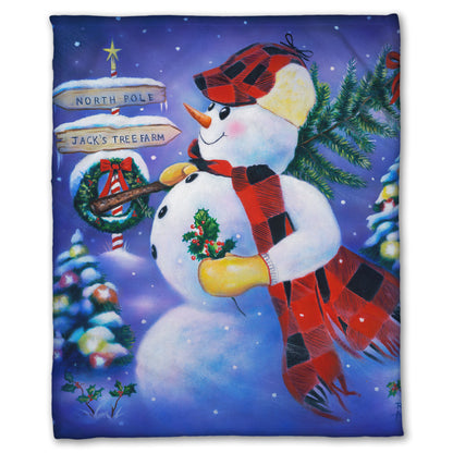 Coral fleece blanket designed with a painting of an anthropomorphized snowman, carrying a small christmas tree as it travels to the north pole.