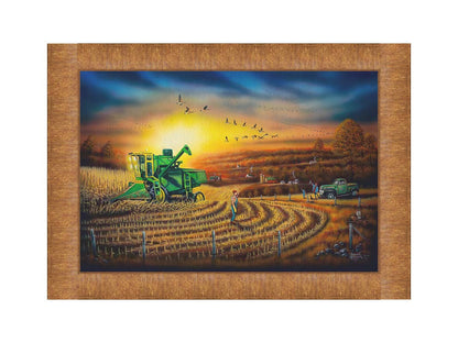 A painting of a harvester at work, gracefully cutting through fields of golden corn stalks. Geese fly overhead, illuminated by the sun on the horizon. Printed on canvas and framed.