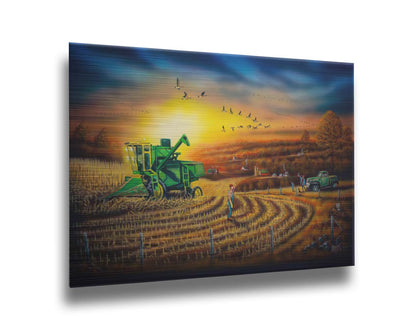 A painting of a harvester at work, gracefully cutting through fields of golden corn stalks. Geese fly overhead, illuminated by the sun on the horizon. Printed on metal.