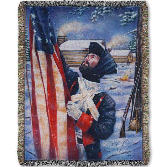 Woven blanket designed with a soldier holding an American flag in a snowy landscape.