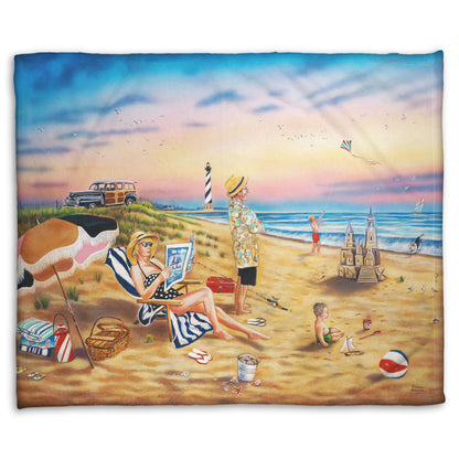 A coral fleece blanket designed with a painting of a family vacationing on the beach. The adults relax while the children play, with one in the sand and another flying a kite with their dog.