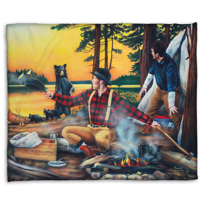 Coral fleece blanket designed with a painting of two men camping and cooking a meal, looking back in shock at an approaching bear and her two cubs.