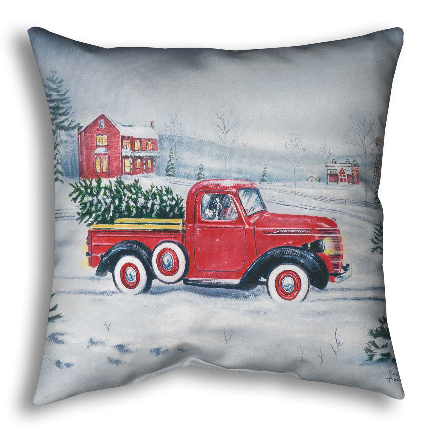 Decorative pillow printed with a red truck and Christmas tree driving through a snowy landscape.