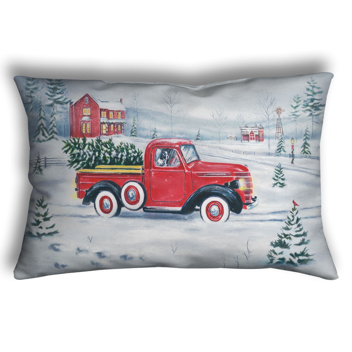 Decorative pillow printed with a red truck and Christmas tree driving through a snowy landscape.