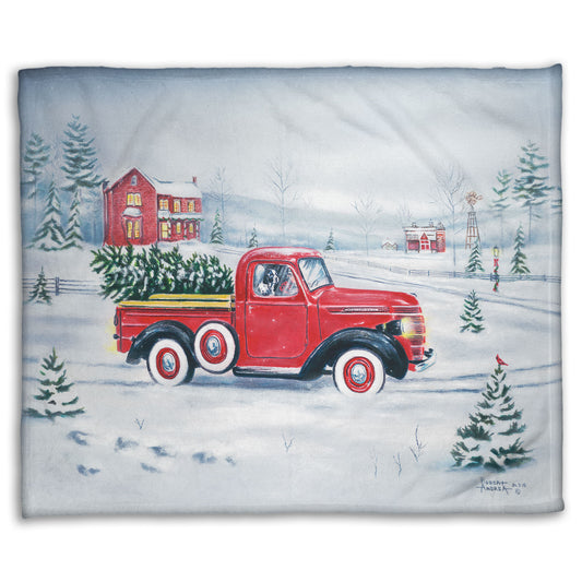 Coral fleece blanket with a red truck and Christmas tree design.
