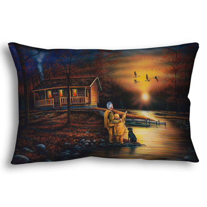 A throw pillow designed with a painting of a man and a child standing by a river and cabin. They are watching geese fly overhead at sunset.