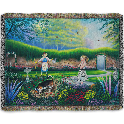 A woven throw blanket designed with a painting of a beautiful garden, but a dog is digging up the rose bushes, ruining them. The woman gardening and a child are looking on in shock.