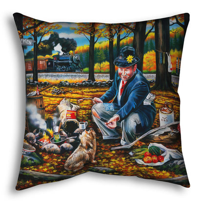 A throw pillow designed after a painting of a man sitting on a log at a campfire in the woods strewn with fall leaves. He is feeding a little dog. A train is passing in the background.