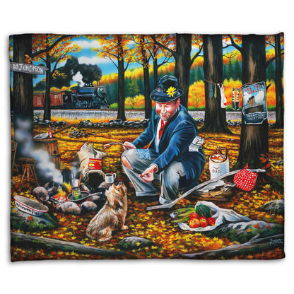 A coral fleece throw blanket designed after a painting of a man sitting on a log at a campfire in the woods strewn with fall leaves. He is feeding a little dog. A train is passing in the background.