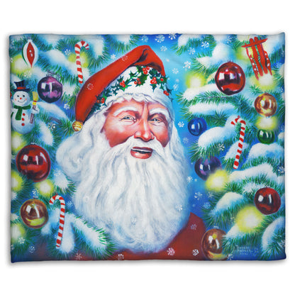 A coral fleece blanket printed with a painting of Santa Claus, bordered by Christmas Trees decorated in lights and baubles.