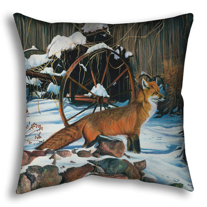 A throw pillow designed with a painting of a red fox in the winter snow. It is standing by some old farming equipment, grasses, and stones.