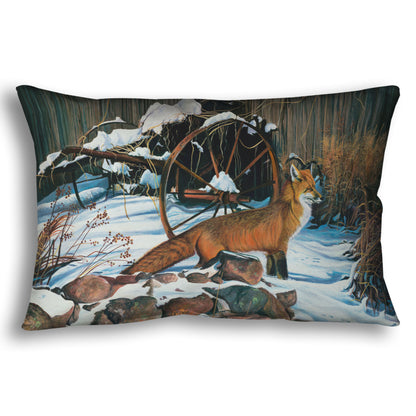 A throw pillow designed with a painting of a red fox in the winter snow. It is standing by some old farming equipment, grasses, and stones.