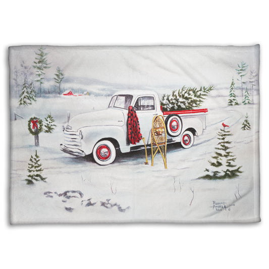 Festive blanket with a vintage truck and Christmas trees design.