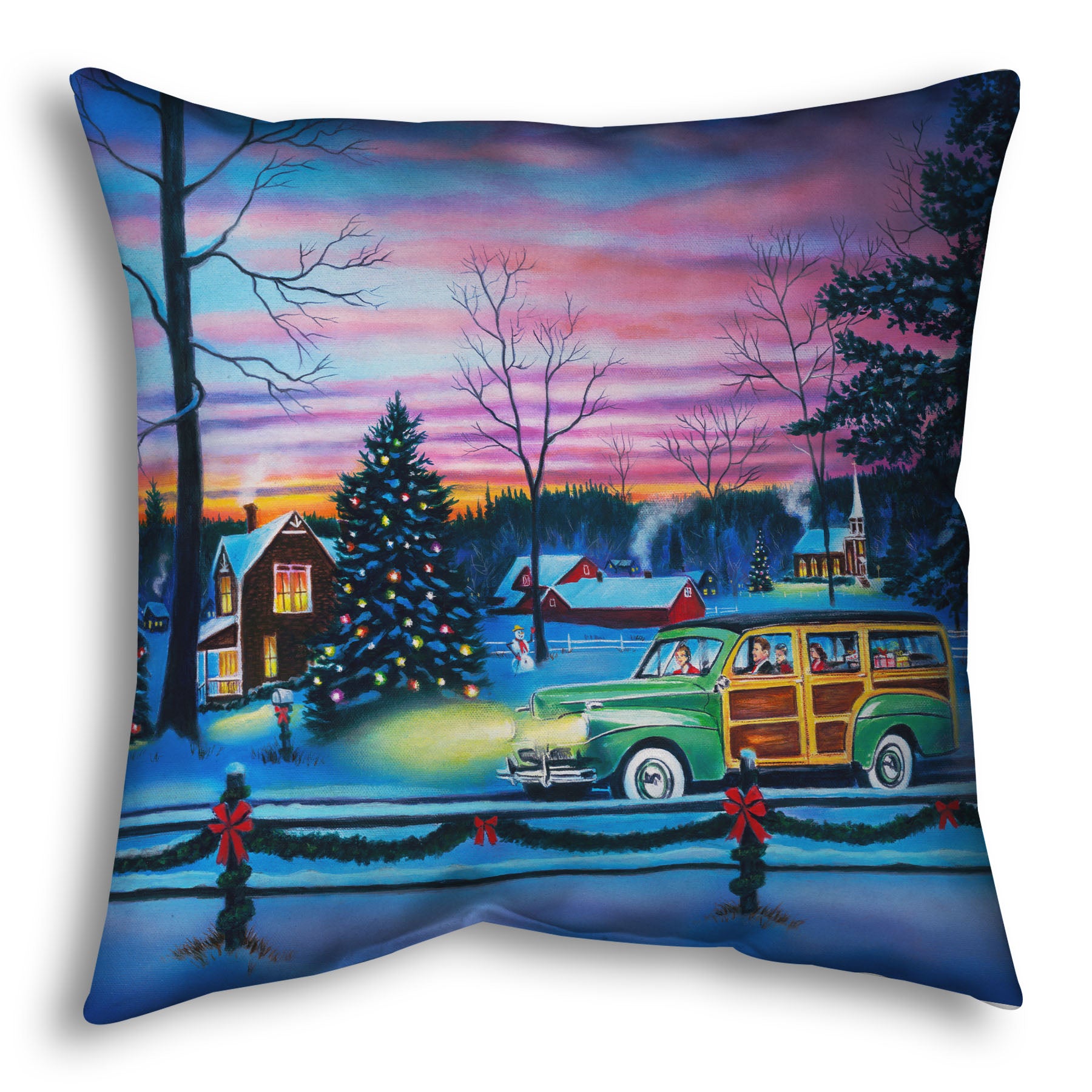 A throw pillow printed with a painting of a snowy town with Christmas lights, where a 1950s family drive past in a car full of presents at sunset.