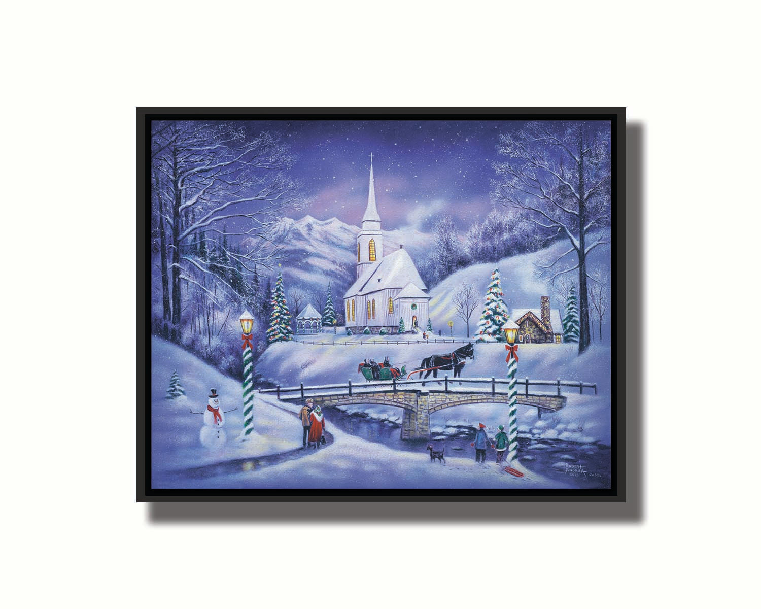 A painting of a snowy mountain town, decorated for Christmas. A tall church sits in the middle of town. A horse-drawn sleigh crosses a bridge over a freezing river. Printed on canvas in a float frame.