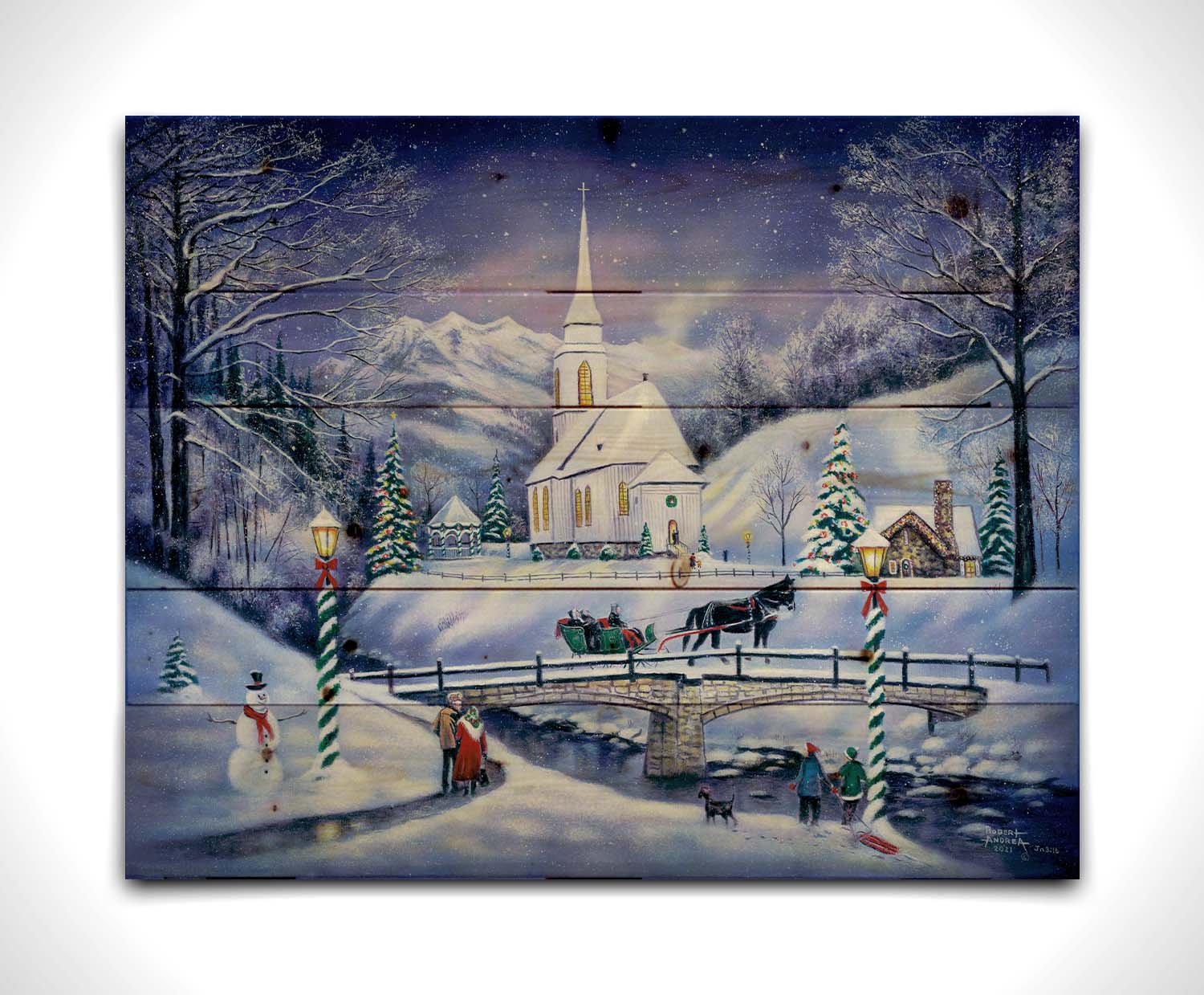 A painting of a snowy mountain town, decorated for Christmas. A tall church sits in the middle of town. A horse-drawn sleigh crosses a bridge over a freezing river. Printed on a wood pallet.