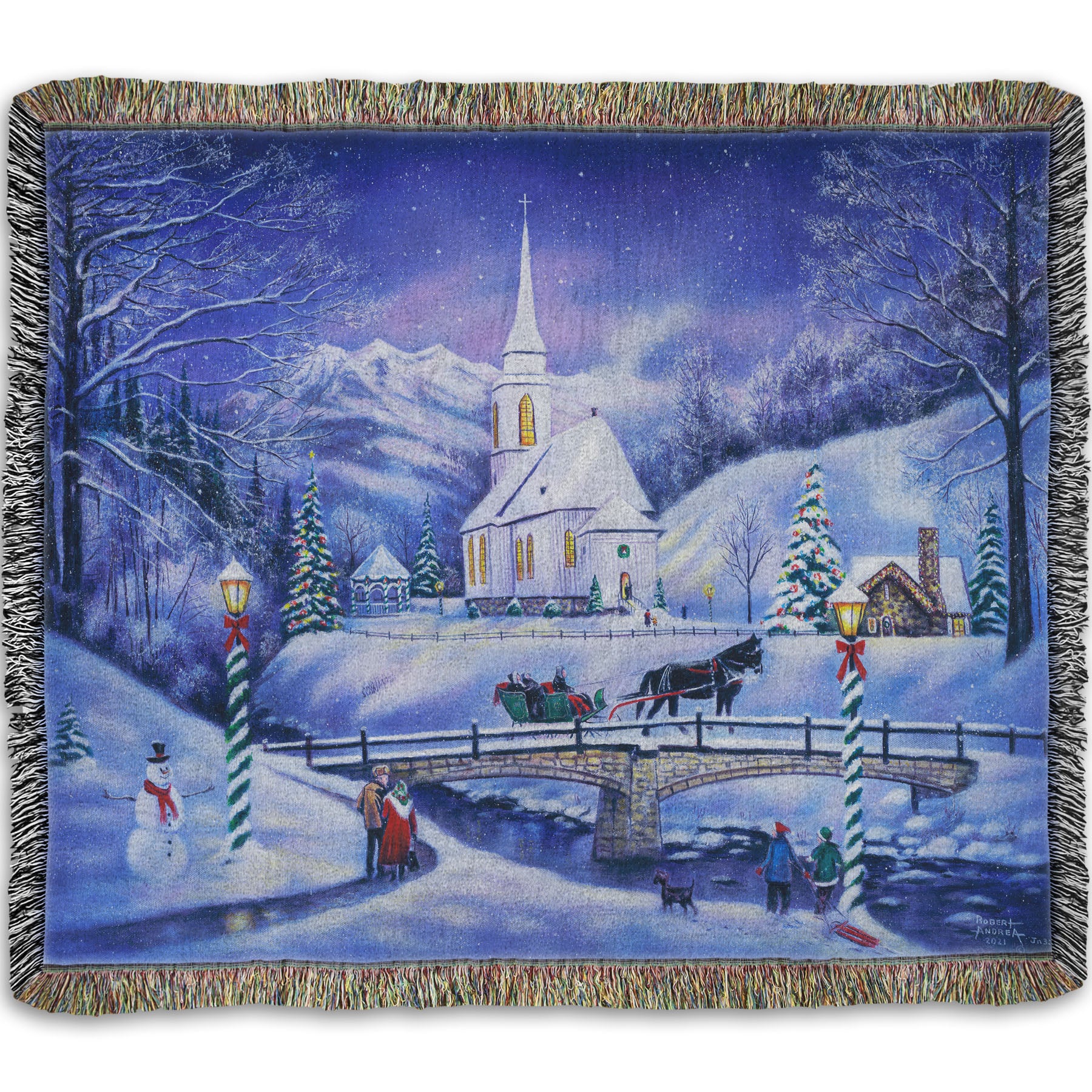 A woven throw blanket designed with a snowy mountain town, decorated for Christmas. A tall church sits in the middle of town.