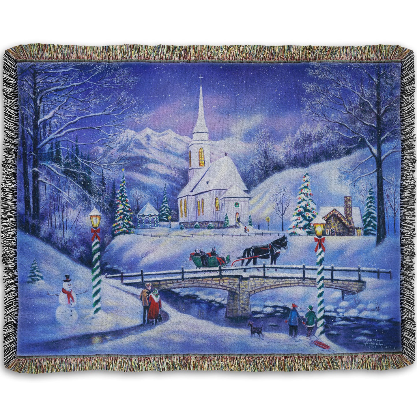 A woven throw blanket designed with a snowy mountain town, decorated for Christmas. A tall church sits in the middle of town.